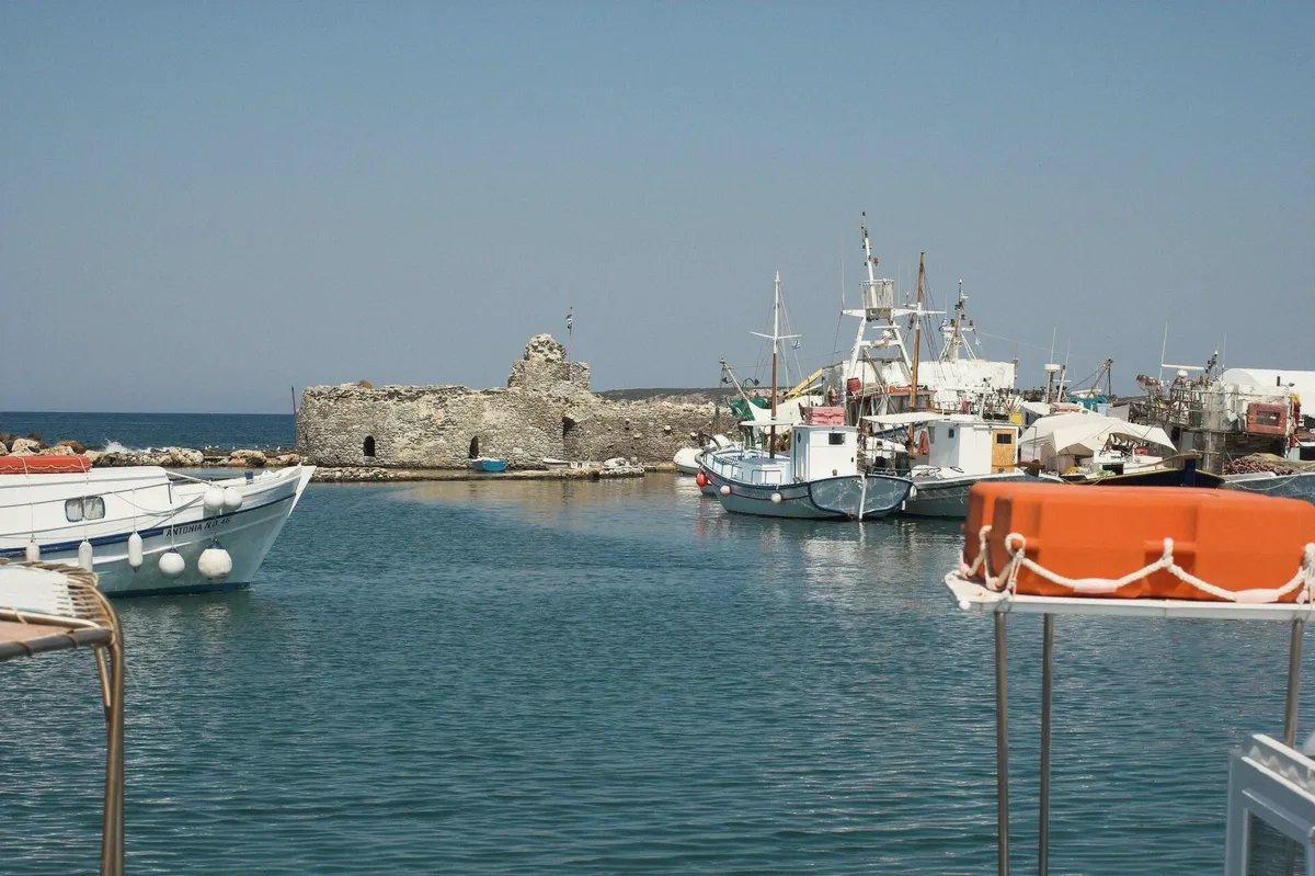 The Venetian sea wall of Naoussa harbour in Paros seen from a boat